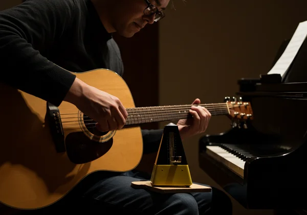 Musician practices slowly with a metronome for precision.